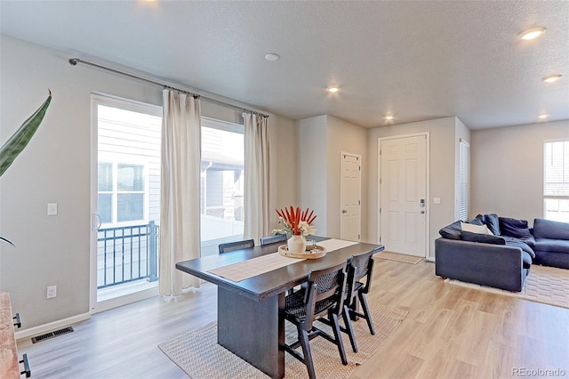 dining area featuring a textured ceiling, light wood-style flooring, visible vents, and recessed lighting