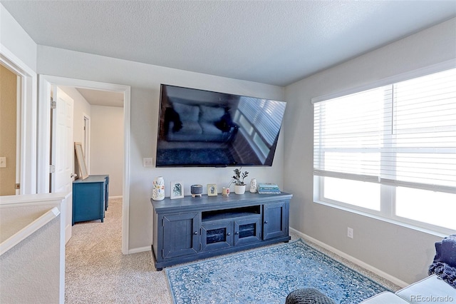 living room featuring a textured ceiling, baseboards, and light colored carpet