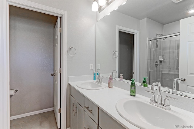 5154 Bittercress Rd, Brighton, CO 80640 - full bathroom with double vanity, tiled shower, tile patterned floors, and baseboards