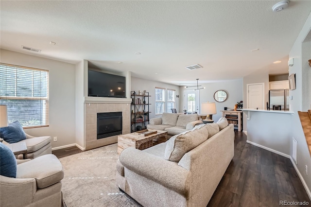 1133 S Richfield St, Aurora, CO 80017 - living room featuring a fireplace, wood finished floors, and a textured ceiling