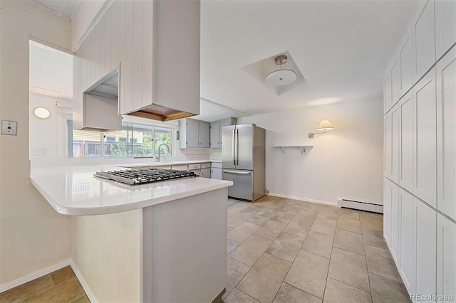 kitchen with a baseboard heating unit, kitchen peninsula, stainless steel appliances, light tile patterned floors, and white cabinets