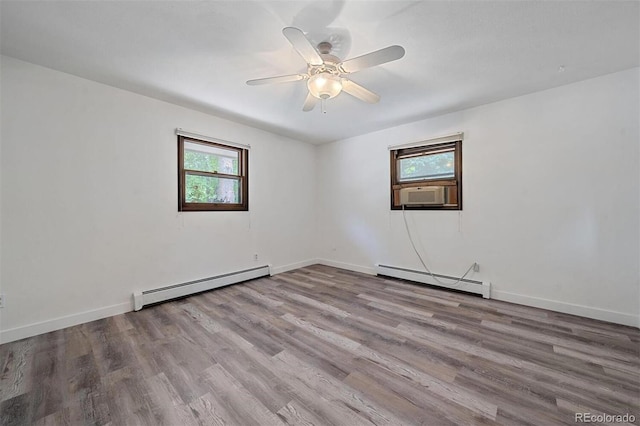 spare room featuring cooling unit, light hardwood / wood-style flooring, and baseboard heating