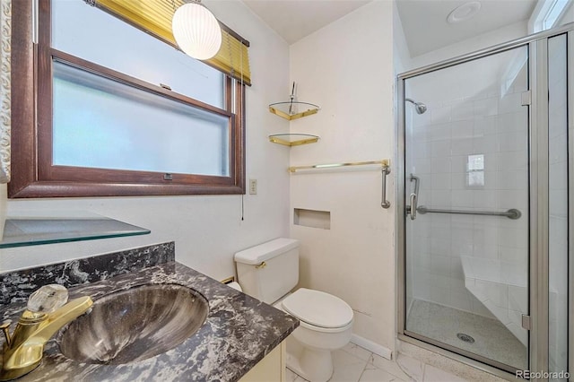 bathroom featuring vanity, a shower with shower door, and toilet