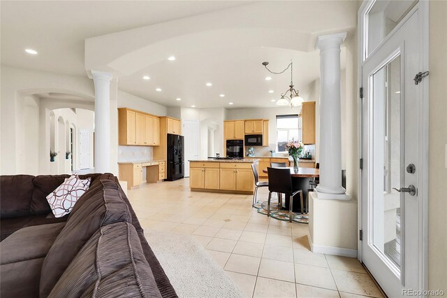 living room featuring ornate columns, light tile patterned flooring, recessed lighting, arched walkways, and baseboards