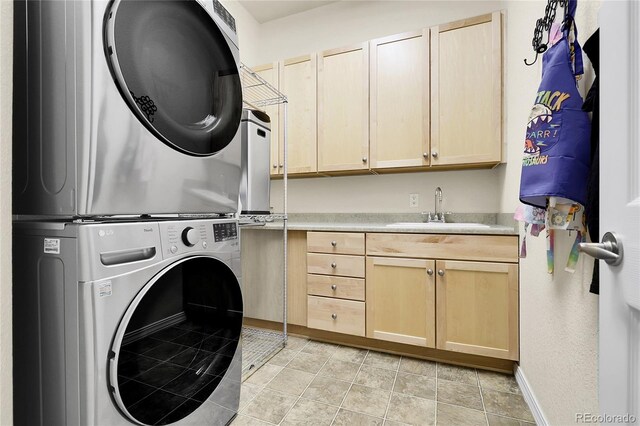 washroom with stacked washer / dryer, cabinet space, and baseboards