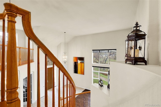 stairs featuring a chandelier, baseboards, and high vaulted ceiling