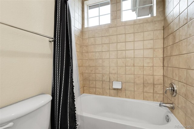 bathroom featuring toilet and shower / tub combo
