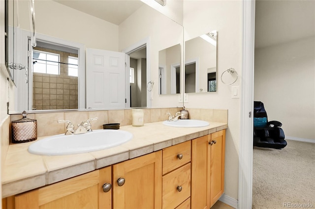 full bathroom featuring double vanity and baseboards