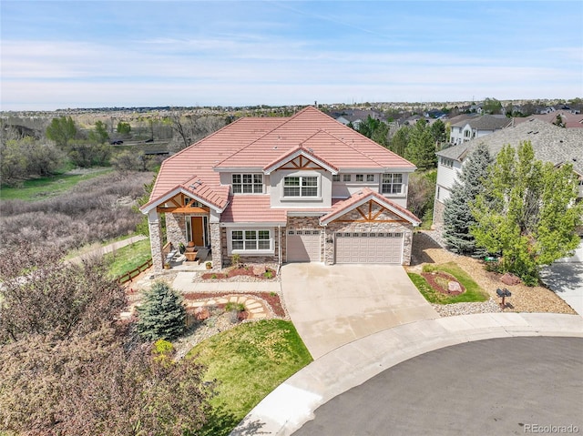 23965 E Kettle Pl, Aurora, CO 80016 - view of front of home with stone siding, a tiled roof, driveway, and an attached garage