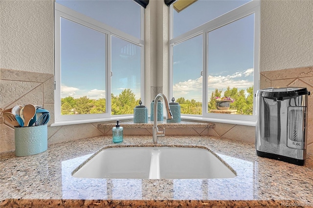 23965 E Kettle Pl, Aurora, CO 80016 - kitchen view of a textured wall, light stone countertops, and tasteful backsplash