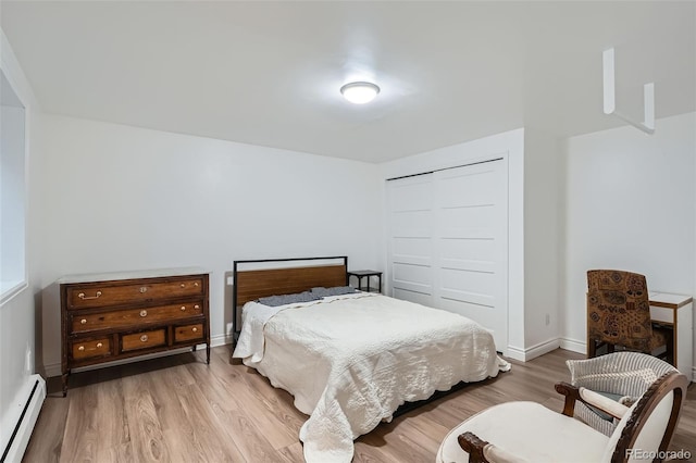 824 S Medea Way, Denver, CO 80209 - bedroom featuring baseboard heating, wood finished floors, baseboards, and a closet