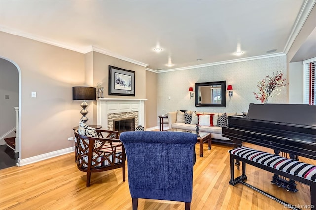824 S Medea Way, Denver, CO 80209 - living room featuring light wood-style flooring, arched walkways, ornamental molding, a fireplace, and stairs