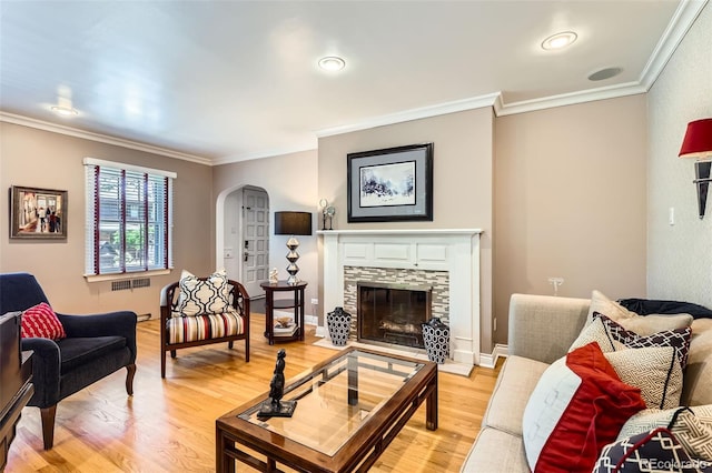 824 S Medea Way, Denver, CO 80209 - living area featuring arched walkways, crown molding, light wood-style floors, a fireplace, and radiator heating unit