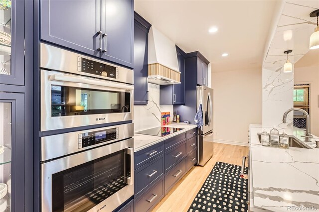824 S Medea Way, Denver, CO 80209 - kitchen with appliances with stainless steel finishes, light stone countertops, light wood-style flooring, pendant lighting, and custom range hood