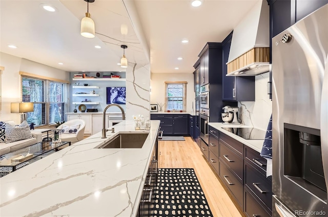 824 S Medea Way, Denver, CO 80209 - kitchen with custom exhaust hood, stainless steel appliances, light wood finished floors, decorative light fixtures, and light stone counters