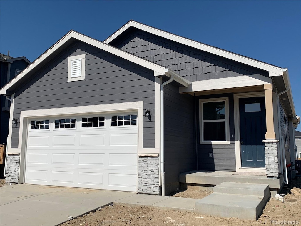 9085 Rifle St, Commerce City, CO 80022 - view of front of property with stone siding, a garage, and driveway