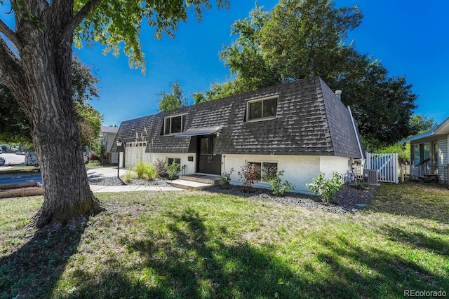 bi-level home featuring a front lawn and central air condition unit