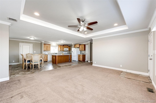 unfurnished living room featuring crown molding, a raised ceiling, and carpet