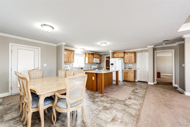 dining room featuring crown molding and light carpet