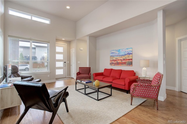 living area with recessed lighting, baseboards, and light wood-type flooring