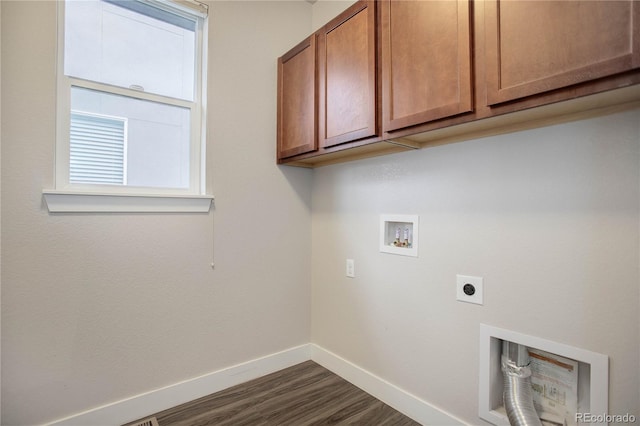 clothes washing area featuring electric dryer hookup, dark wood-type flooring, cabinet space, baseboards, and hookup for a washing machine