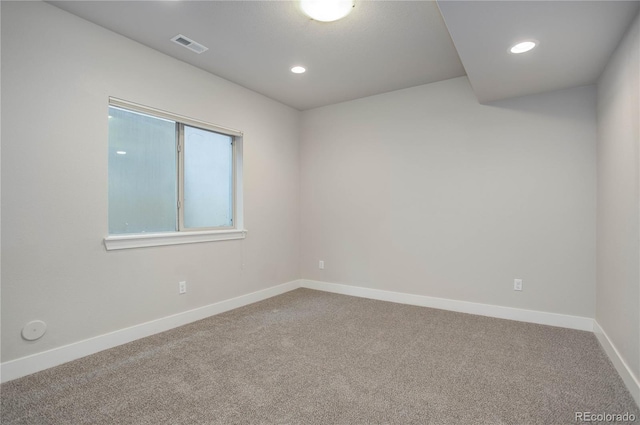 spare room featuring recessed lighting, visible vents, carpet floors, and baseboards