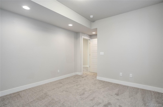 unfurnished room featuring recessed lighting, light colored carpet, visible vents, and baseboards