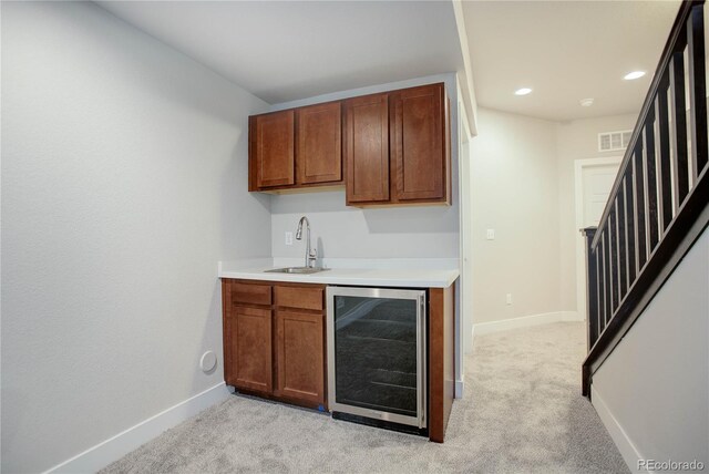 bar featuring baseboards, a sink, stairs, wine cooler, and light carpet