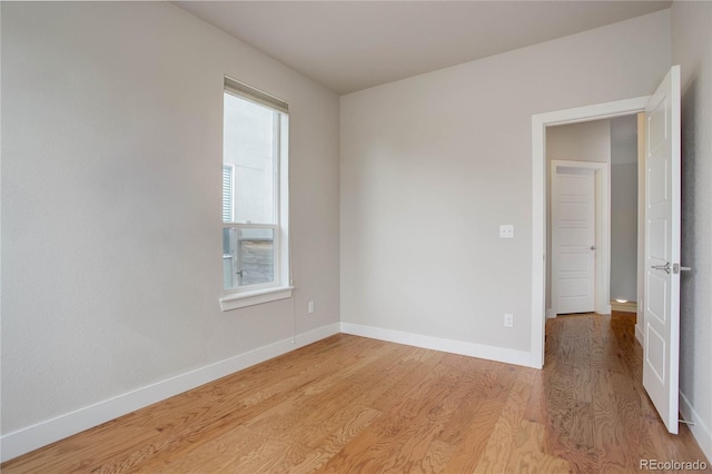 unfurnished room with light wood-type flooring and baseboards