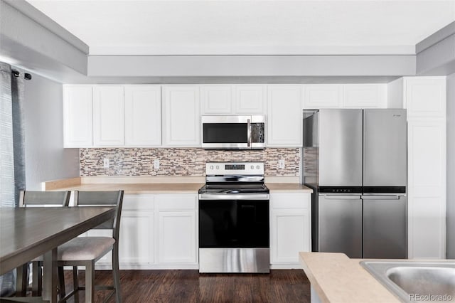 kitchen with white cabinetry, backsplash, stainless steel appliances, and dark hardwood / wood-style floors