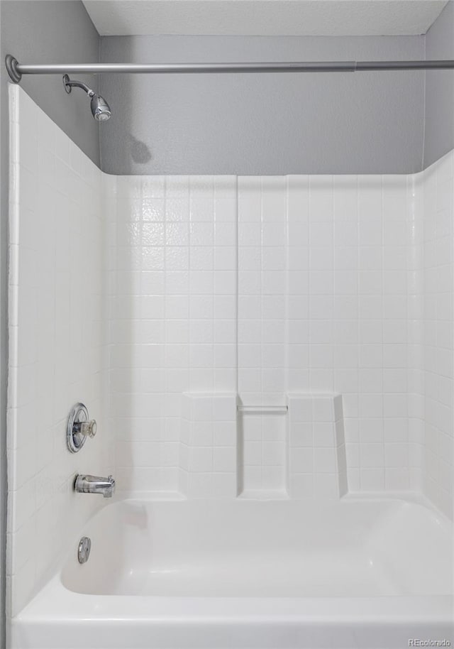 bathroom featuring shower / bath combination and a textured ceiling