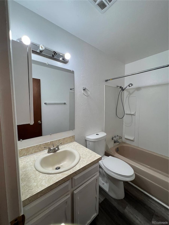 11812 E Alaska Ave, Aurora, CO 80012 - full bathroom with wood finished floors, vanity, bathing tub / shower combination, and a textured wall