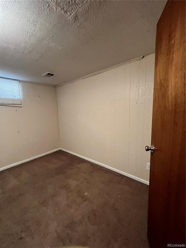 11812 E Alaska Ave, Aurora, CO 80012 - spare room with dark colored carpet and a textured ceiling