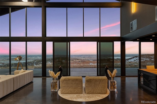 dining room with concrete flooring, expansive windows, and a water view