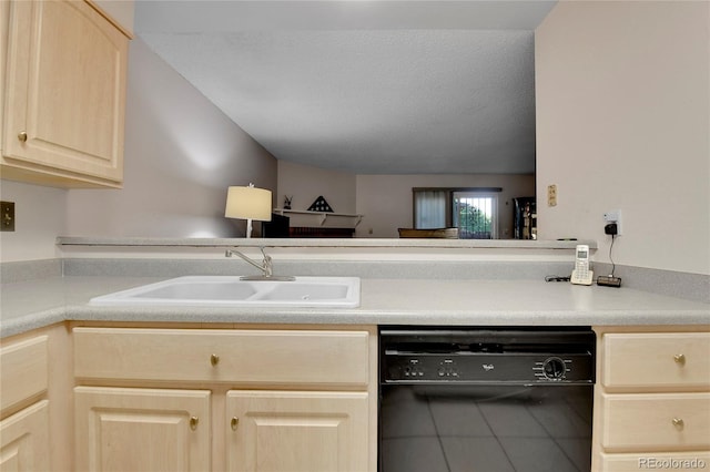 kitchen with light brown cabinetry, black dishwasher, sink, and a textured ceiling