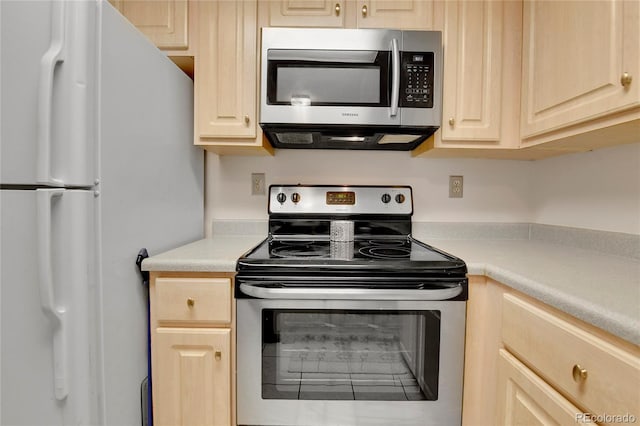 kitchen featuring stainless steel appliances and light brown cabinets