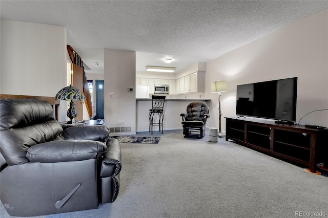 carpeted living room featuring a textured ceiling