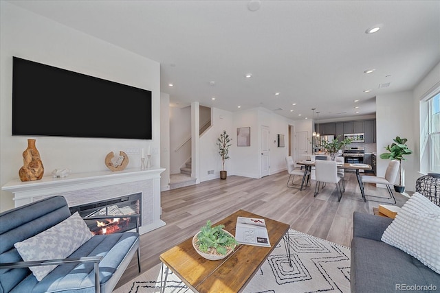 6106 W 28th Ct, Edgewater, CO 80214 - living room with recessed lighting, light wood-type flooring, stairs, and a glass covered fireplace