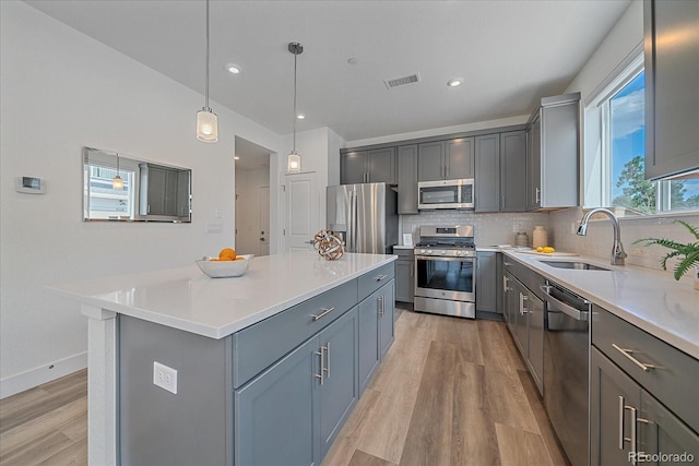 6106 W 28th Ct, Edgewater, CO 80214 - kitchen with stainless steel appliances, gray cabinetry, light wood-type flooring, backsplash, and recessed lighting