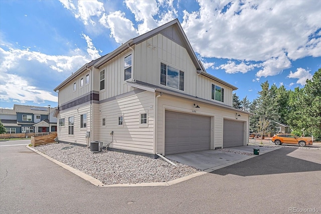 6106 W 28th Ct, Edgewater, CO 80214 - view of side of property with board and batten siding, an attached garage, and driveway