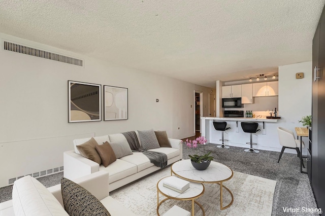 1020 15th St Unit 20F, Denver, CO 80202 - living room featuring light carpet, a textured ceiling, and visible vents