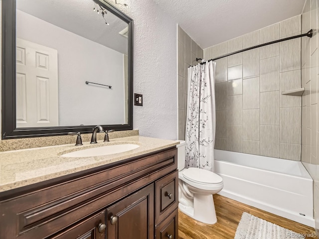 5339 S Windermere St, Littleton, CO 80120 - full bathroom with vanity, toilet, wood finished floors, shower / bath combo with shower curtain, and a textured wall