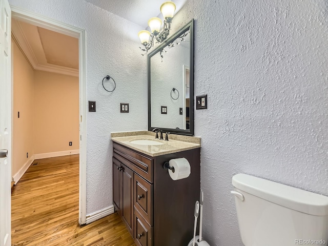 5339 S Windermere St, Littleton, CO 80120 - half bathroom featuring toilet, wood finished floors, ornamental molding, vanity, and a textured wall