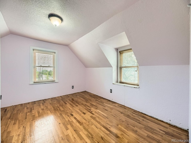 5339 S Windermere St, Littleton, CO 80120 - additional living space featuring wood finished floors, vaulted ceiling, and a textured ceiling