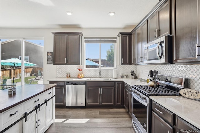 1846 Osprey Dr, Brighton, CO 80601 - kitchen featuring stainless steel appliances, a sink, dark brown cabinets, and recessed lighting