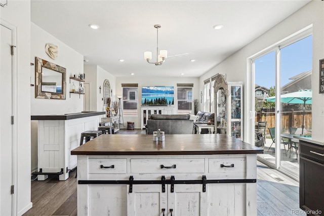 1846 Osprey Dr, Brighton, CO 80601 - kitchen featuring a chandelier, white cabinetry, wood finished floors, recessed lighting, and hanging light fixtures