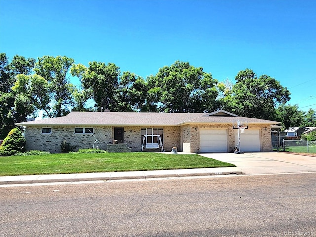 single story home with driveway, a front yard, a garage, brick siding, and fence