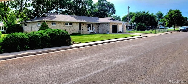 ranch-style house with an attached garage, a front lawn, and brick siding