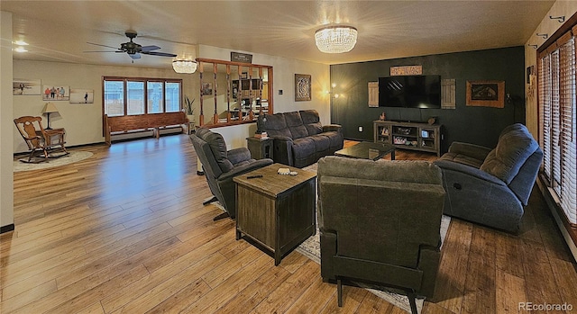 living area featuring baseboards, ceiling fan, a baseboard heating unit, and light wood-style flooring