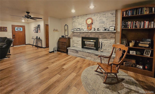 living area with ceiling fan, a fireplace, recessed lighting, baseboards, and wood finished floors